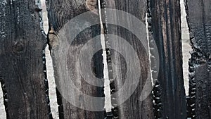 Burnt fence boards after a fire in a private house.