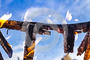 Burnt fence close-up on the ashes of a large fire, on a blurred background with a bokeh effect