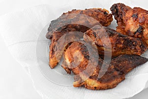 Burnt fried chicken wings on white tissue background  for reduced the cooking oil