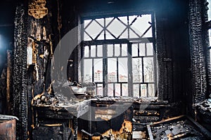 Burnt house interior. Burned kitchen, remains of furniture in black soot