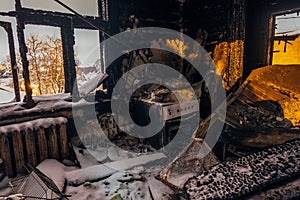 Burnt house interior. Burned kitchen, remains of stove and furniture in black soot