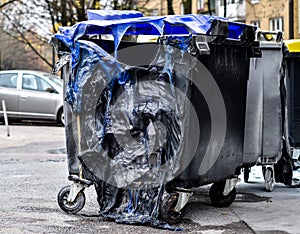 Burnt and melted trash can form a fire.