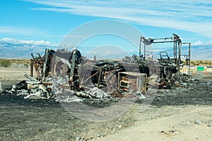 A burnt motorhome in the desert