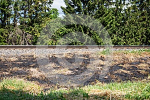 Burnt old dry grass. Fire accident, extremely hot weather and nature. Railway track