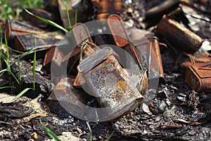 Burnt old rusty cans thrown away in the forest