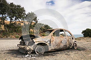 Burnt out car on the side of a road