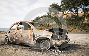 Burnt out car on the side of a road