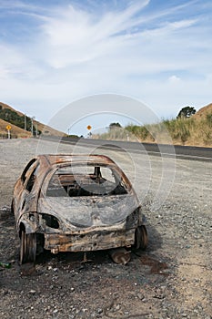 Burnt out car on the side of a road