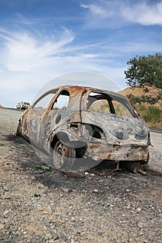 Burnt out car on the side of a road