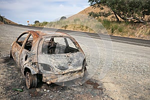 Burnt out car on the side of a road