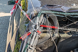 Burnt out car after a violent accident with police barrier tape in red and white with the German word for police barricade, German