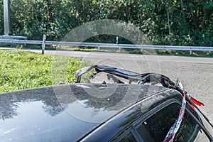 Burnt out car after a violent accident with police barrier tape in red and white with the German word for police barricade, German