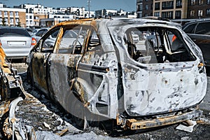 Burnt out minivan near with residential buildings.