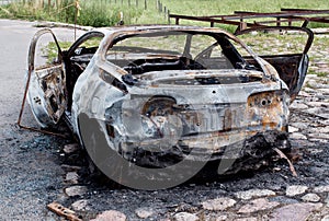 Burnt out rusted old car near the road