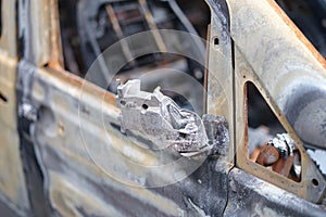 Burnt-out rusty cars on city street, vandalism