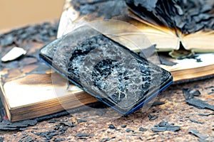 Burnt phone and charred books on the table in the office, traces of fire