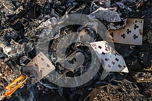 Burnt playing cards in smoke ashes after fire flame. Struggle with gambling addiction