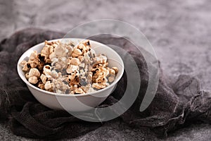 Burnt popcorn in the small white bowl on ceramic