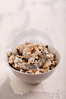 Burnt popcorn in the small white bowl on ceramic