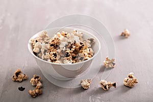 Burnt popcorn in the small white bowl on ceramic