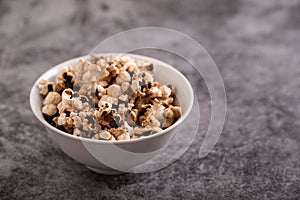 Burnt popcorn in the small white bowl on ceramic