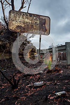 Burnt road sign, rubbish and landscape after bush fires Australia