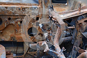 Burnt rusty abandoned car in parking lot