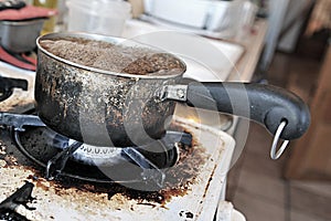 Burnt saucepan on dirty cooker