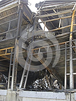 Burnt structures of the metal frame of an industrial building after a fire. Deformations of columns and beams from high