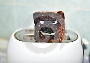 Burnt toast with an angry face expressing the emotion of sadness or sarcasm. Burnt toast bread slices out of a toaster. Ð¡oncept