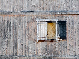 Burnt window shutter in dilapidated wooden building