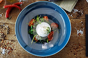 Burrata with paprika-truffle jam and cherry-cluster tomato salad. Delicious healthy Italian traditional food closeup