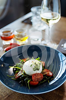 Burrata with paprika-truffle jam and cherry-cluster tomato salad. Delicious healthy Italian traditional food closeup