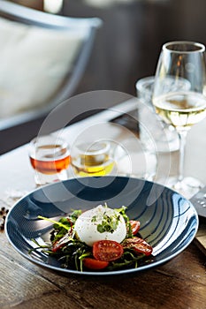 Burrata with paprika-truffle jam and cherry-cluster tomato salad. Delicious healthy Italian traditional food closeup