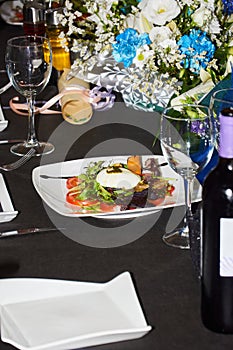 Burrata salad on a restaurant table surrounded by different objects