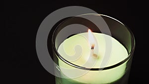 Burring aroma candle on black background close up. Wooden stick lights candle, filmed on high framerate. Ignition of aroma candle