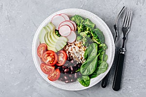 Burrito Buddha Bowl with wild rice and broccoli, spinach, black beans, tomatoes, avocado and radish