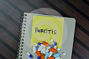 Bursitis write on sticky notes isolated on Wooden Table
