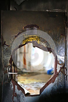 Burst, bent door with sign: Heizraum - Unbefugten ist der Zutritt verboten (Boiler room - Off limits to unauthorized personnel)