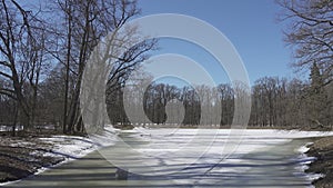 The burst ice and ice-holes on the forest lake on the forest lake in spring sunny day