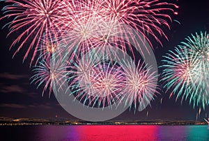 Bursting fireworks illuminate the night sky with a dazzling display of color and light, painting the darkness with