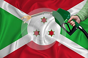 BURUNDI flag Close-up shot on waving background texture with Fuel pump nozzle in hand. The concept of design solutions. 3d