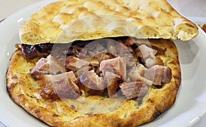 Buryan lamb slow-cooked in a pit served on a flat bread