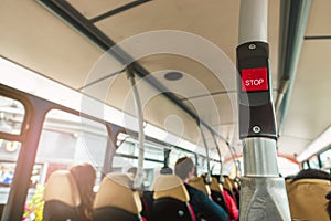 Bus bell switch for stop inside the public bus Brighton & Hove in UK with passenger on the bus.