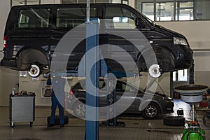 Bus, car raised on a hydraulic jack. Suspension repair, tire change