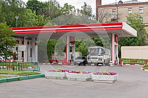 Bus and car refuel at gas station