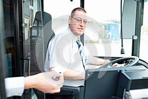 Bus driver selling tickets in bus