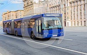 bus goes along street. blurred motion