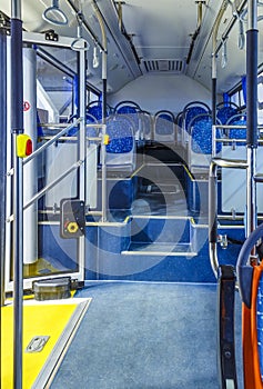 Bus inside, city transportation white interior with blue seats in row, retirement places, open doors, handles for