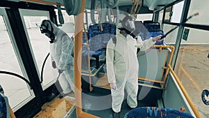 Bus interior is getting disinfected by experts in hazmat suits